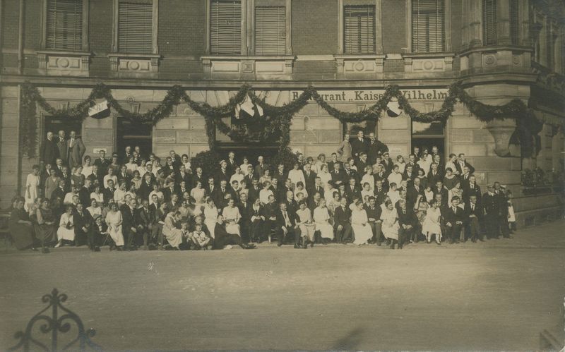 Ein schwar weiß Foto mit Menschen vor der Gaststätte.