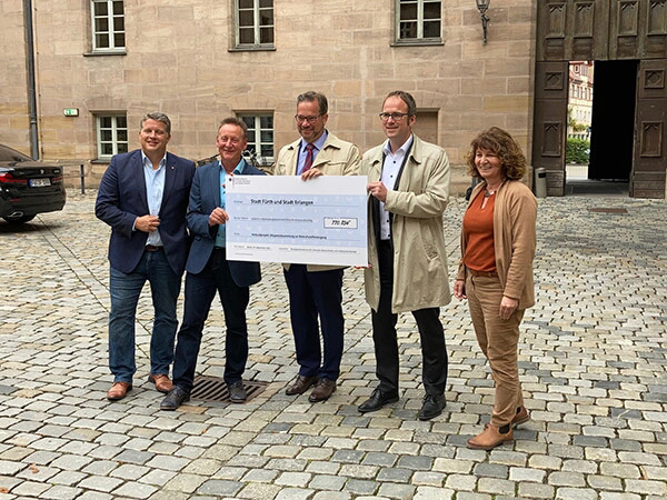 Oberbürgermeister janik und weitere Personen bei der Scheckübergabe.