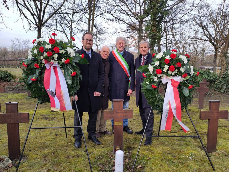 Ein Gruppenbild, vor der Gruppe sind zwei Kränze aufgebaut.