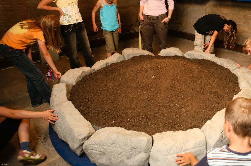 Mehrer Kinder bilden einen Kreis im Innenraum des Museums. 