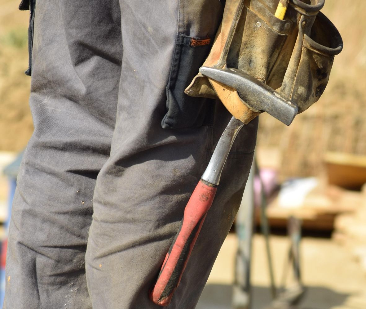 Ein Bauarbeiter mit einem Hammer in der Hand. 