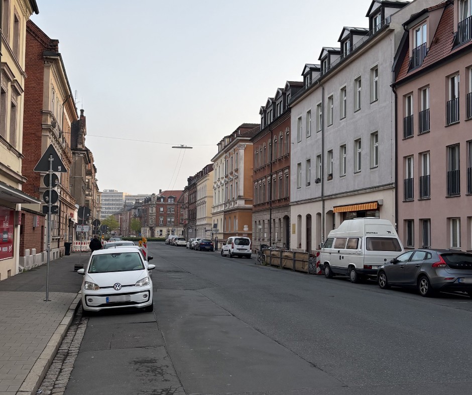 Eine Straße mit Häuser und Autos. 