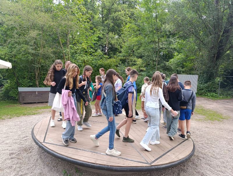 Mehrere Kinder stehen auf einem runden Spielgerät.