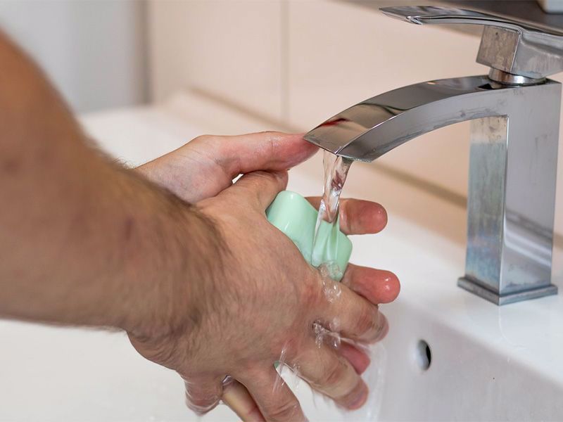 Hände waschen unter fließendem Wasser mit Seife 