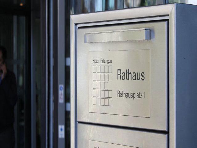 Briefkasten am Eingang des Rathauses mit dem Logo und den Schriftzügen Rathausplatz 1 und Stadt Erlangen.