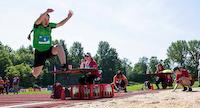 Child doing the long jump with children in the background