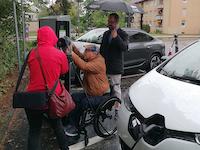 A man in a wheelchair refueling his car.