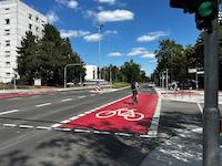 Ein Radfahrer auf einer roten Fahrradspur.