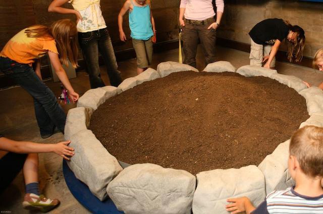 Several children form a circle inside the museum.