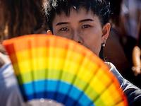 Eine Person hält einen regenbogen Fächer.