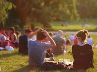 Young people sit on the grass.