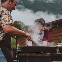 Menschen beim Grillen in Freizeitanlage.