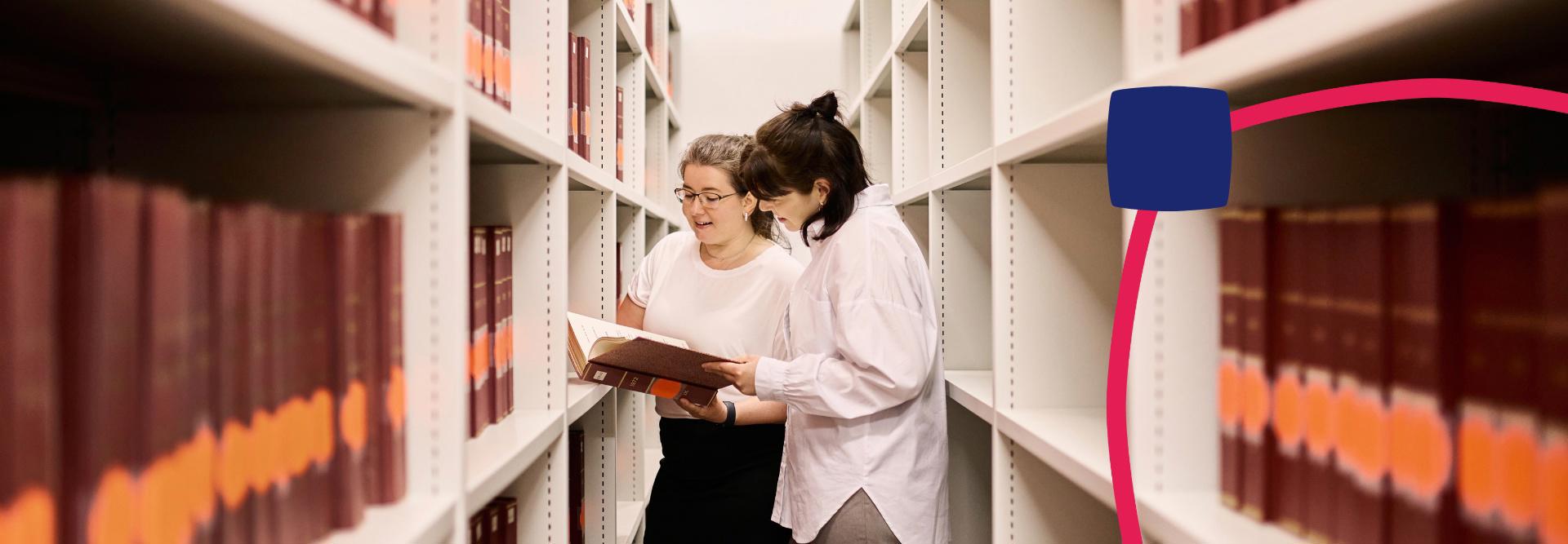 Mitarbeiterinnen sehen gemeinsam in ein Buch.